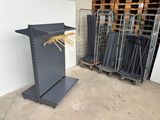 two metal racks with clothes hangers on them in a warehouse