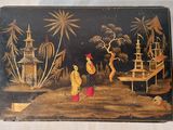 une boîte noire ornée d'une peinture, posée sur une table