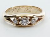 gros plan d'une bague en or ornée de trois diamants