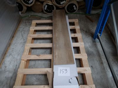une palette en bois portant un numéro, dans un entrepôt