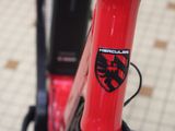 a close up of a red bike with a black emblem on it