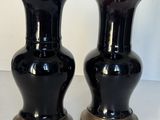 deux vases noirs posés sur une table blanche
