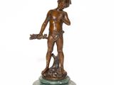 bronze statue of a boy with a dog on a marble base