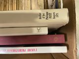 many books stacked on top of each other in a box