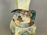 un vase avec un oiseau posé sur une table