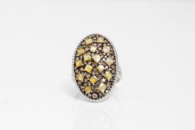 une bague ornée de diamants bruns et blancs sur un fond blanc