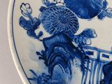 a blue and white plate with a picture of flowers on it