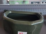 a green bowl on a shelf in a store