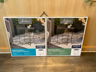 two boxes of outdoor furniture sitting on the floor next to each other