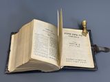 un livre ouvert sur lequel trône une statue en or