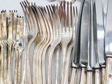 a lot of silver forks and spoons on the table