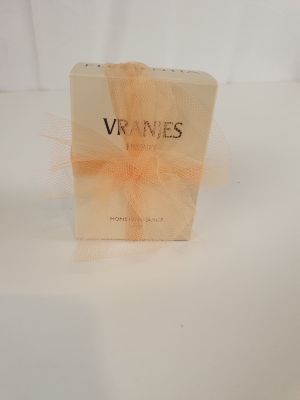 une photo d'un coffret de parfum posé sur une surface blanche