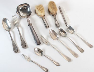 beaucoup de cuillères, de fourchettes et de brosses sur la table