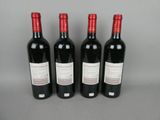 three bottles of red wine are lined up on a table