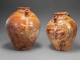 deux vases marron ornés de motifs, placés côte à côte