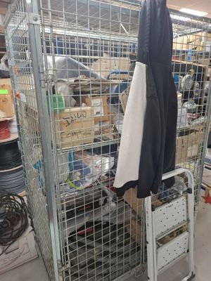 a large metal cage with a coat hanging on it