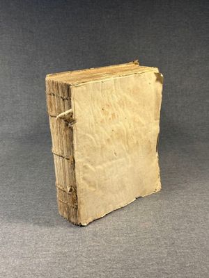 an old book sitting on top of a table next to a gray background