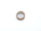 gros plan d'une bague en or sur une surface blanche