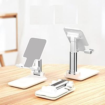 two cell phones sitting on a table with a stand