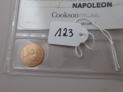a gold coin and a small piece of paper on a table