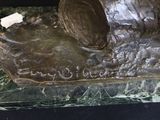 a bronze statue of a dog on a marble base