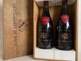 two bottles of wine are in a wooden box on a white surface