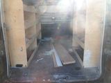 a picture of the inside of a van with a lot of wood in it