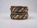 a close up of a stack of three rings on a white surface