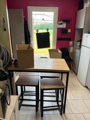 a kitchen with a table and four stools in it
