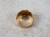 a gold ring sitting on a white surface