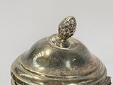 a silver teapot with a lid on a white table