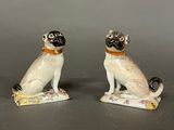 pair of porcelain figurines of a pug dog and a cat