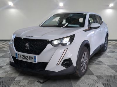 la voiture blanche est garée dans une grande pièce au sol en damier