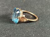 a close up of a ring with a blue topaz stone