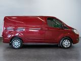 the red van is parked in a large room with a white wall