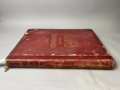 un vieux livre rouge posé sur une table blanche
