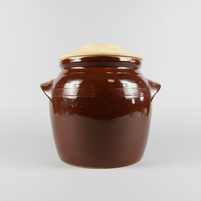 a brown pot with a lid on a white surface