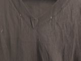 a black shirt hanging on a hanger on a white wall