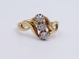a close up of a gold ring with two diamonds on it