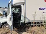 a truck that is sitting in the grass with its door open
