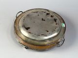 a silver plate with a handle on it on a table