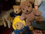 many teddy bears that are sitting together on a bed