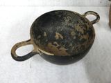 a black and gold pot sitting on a white surface