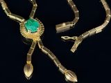 an image of a gold necklace with a green stone on it