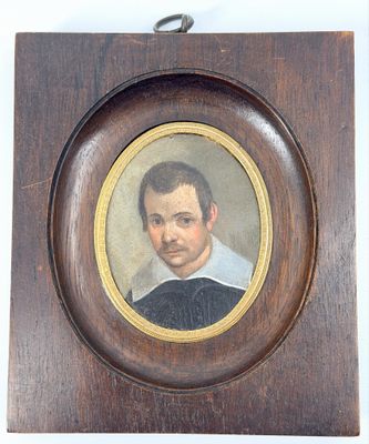 portrait d'un homme vêtu d'une chemise noire et blanche, dans un cadre en bois