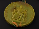 a green medallion with a picture of a man and a woman on it