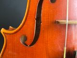 close up of a violin ' s bow and strings against a black background