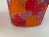 two cups with hearts on them sitting on a table
