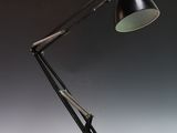 une lampe noire posée sur une table près d'un mur