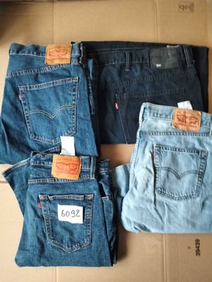 Trois paires de jeans Levi's sont posées sur une boîte en carton